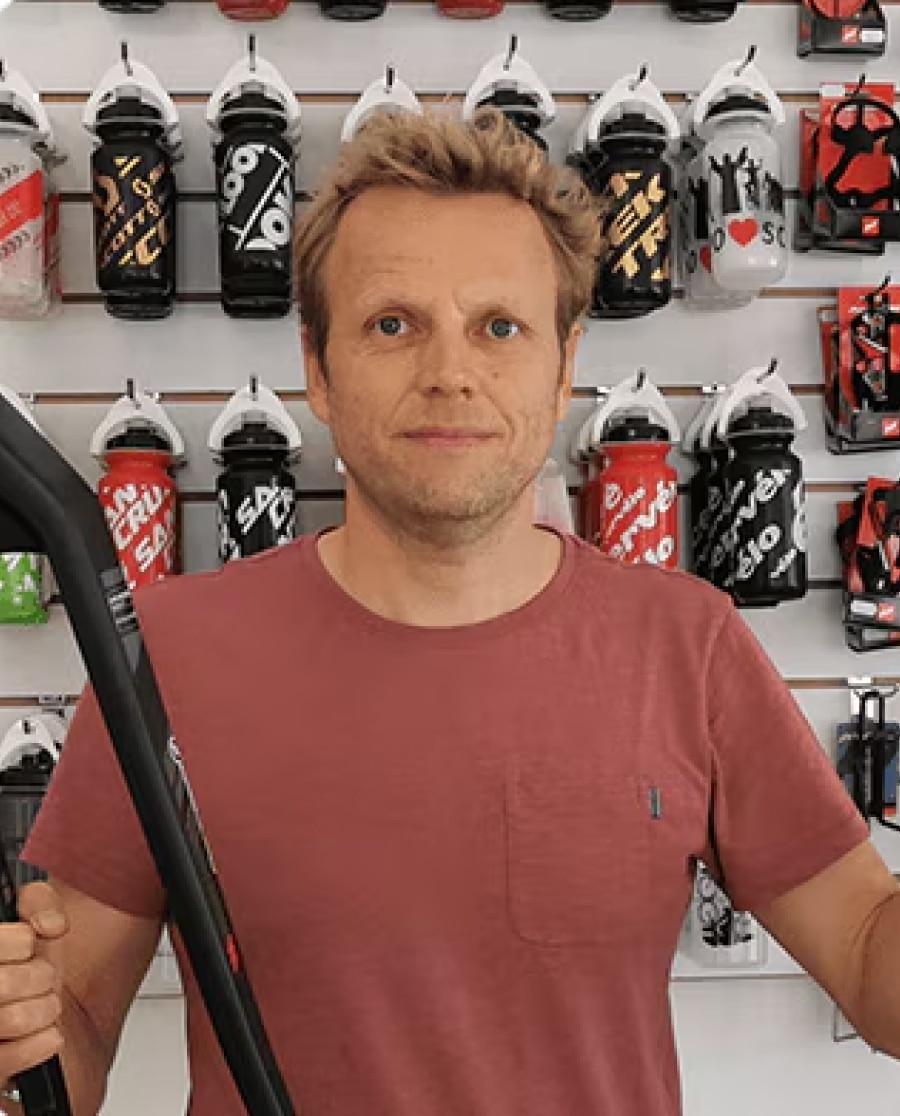 Man Holding Bicycle Part in Sports Shop Display